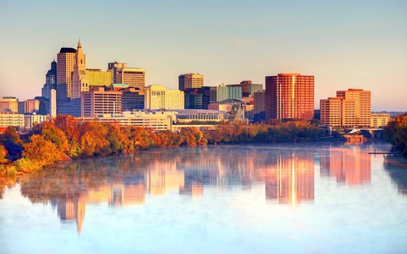 a city skyline with trees and water